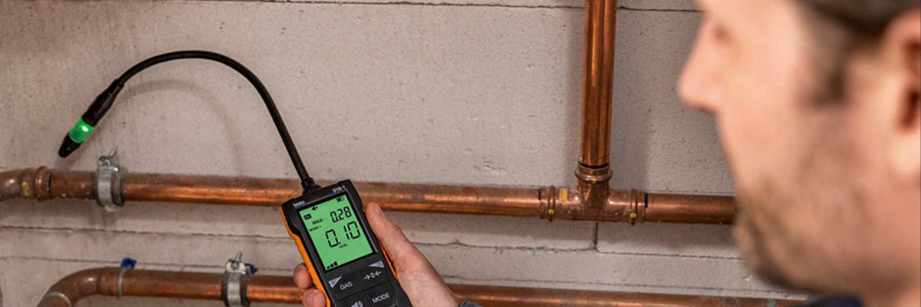 Technician using an electronic gas leak detector
